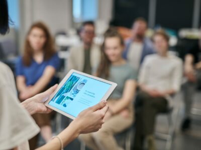 Une personne avec une tablette fait une présentation à une assemblée