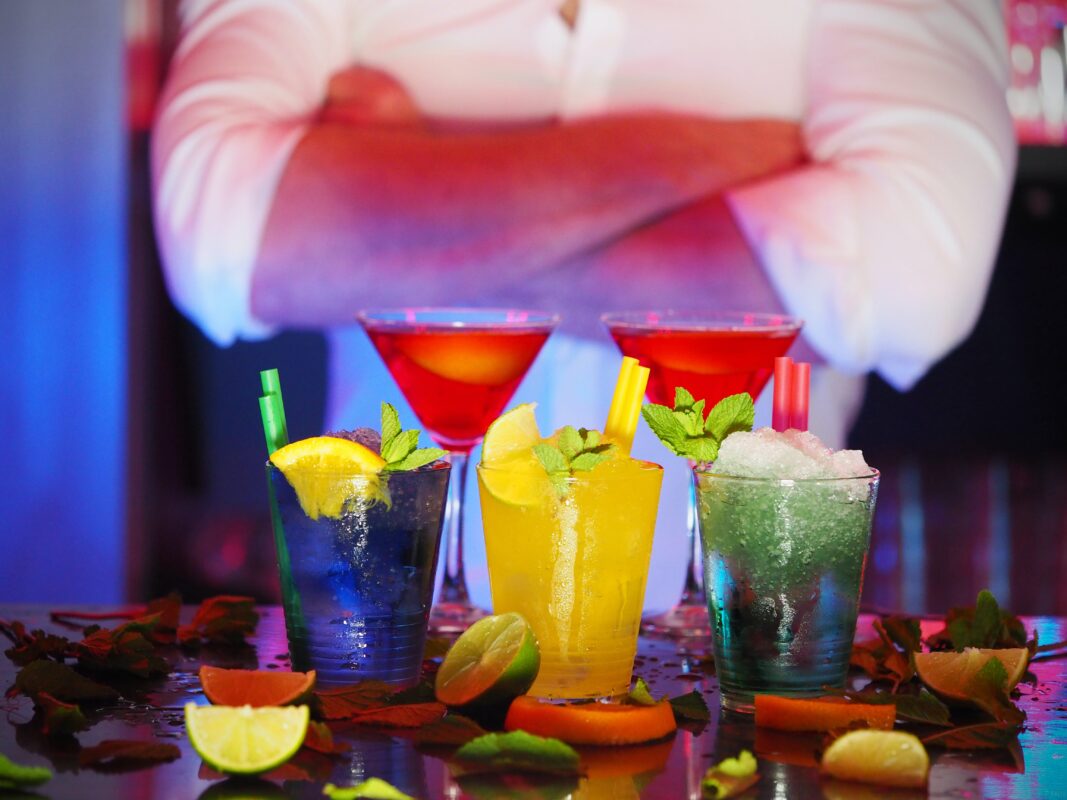 Un barman devant les cocktails qu'il a préparé