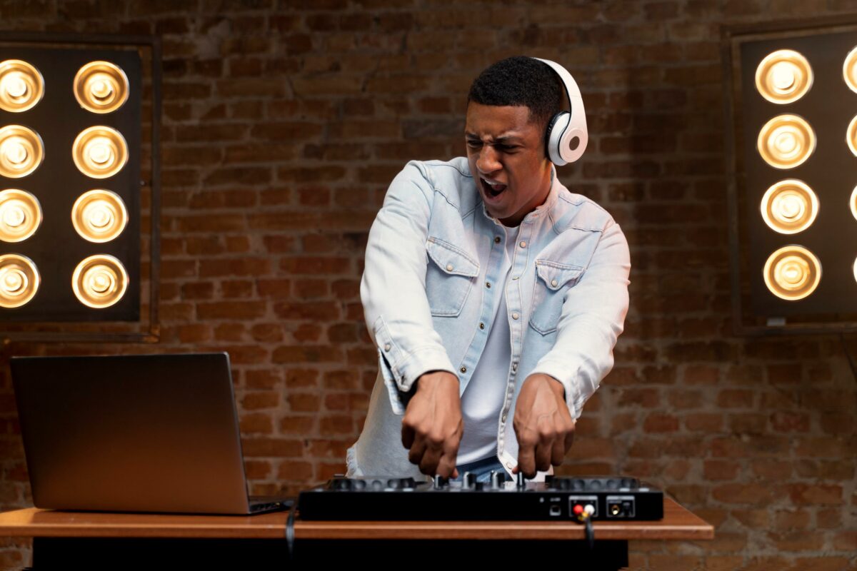 Un DJ mixe. On voit sa platine , son ordinateur et ses lumières.