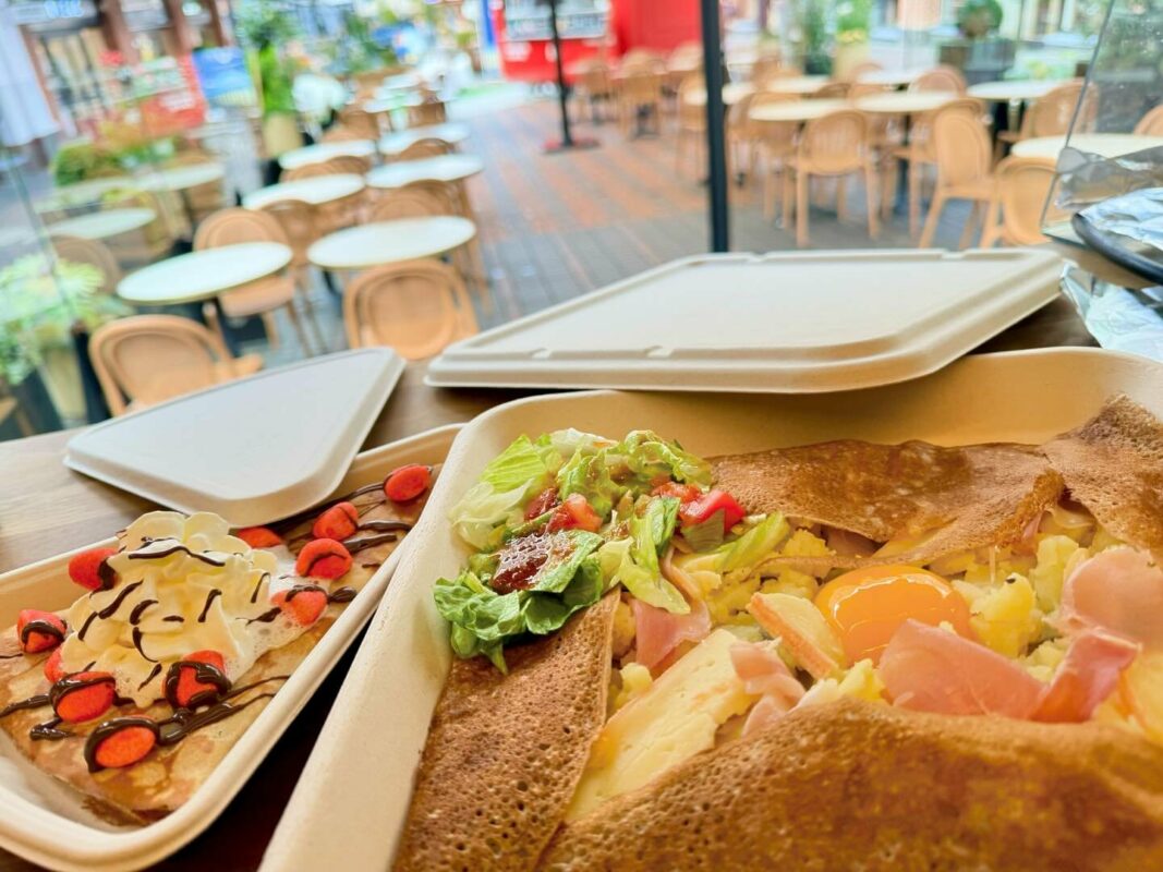 Assiette servie par la Crêperie Ted comprenant une galette complète accompagnée de salade fraîche et une crêpe dessert gourmande avec chantilly, fraises tagada et chocolat chaud